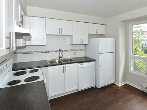 a kitchen with white cabinets and a white refrigerator